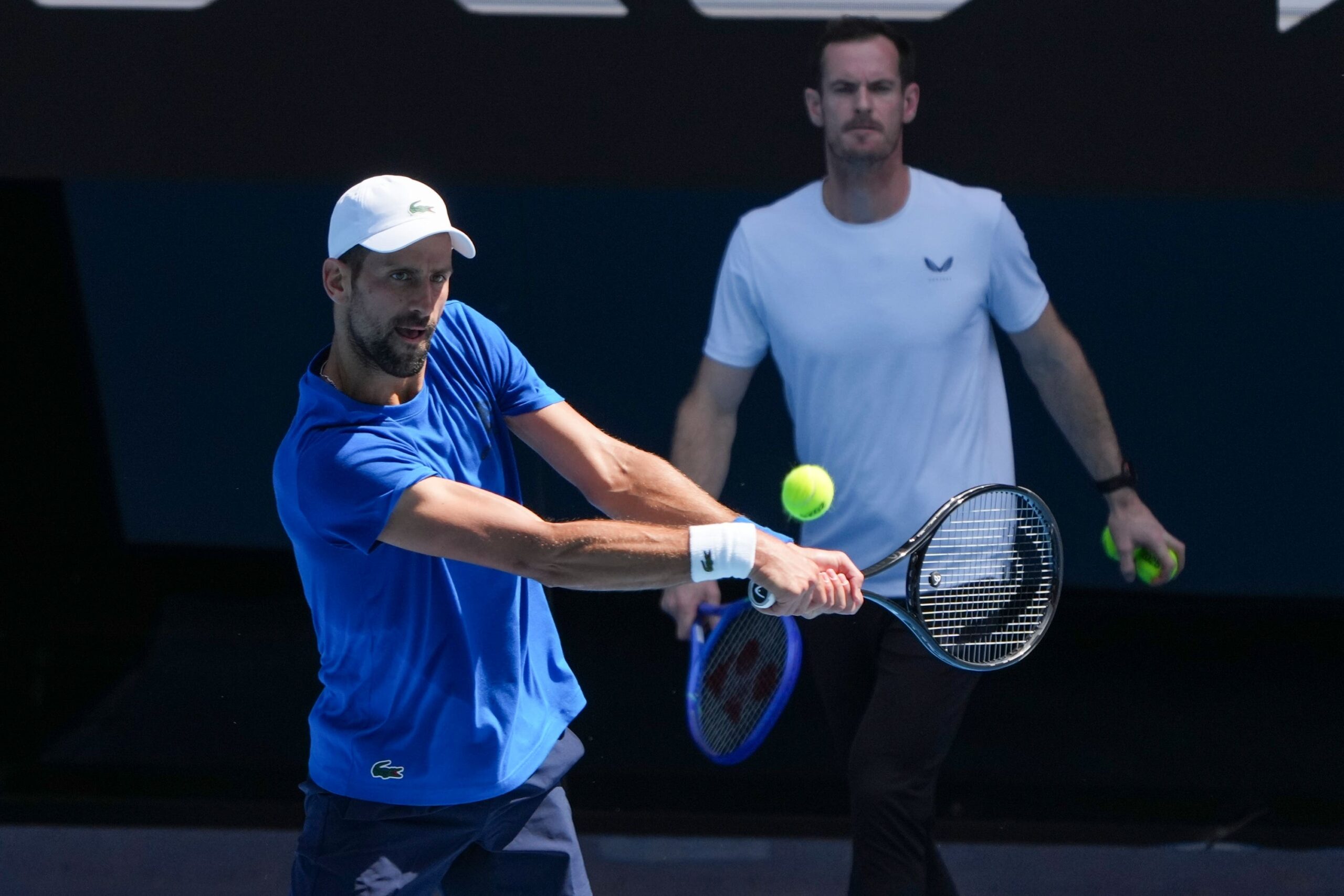 Andy Murray, right, watches Novak Djokovic practise (Mark Baker/AP)